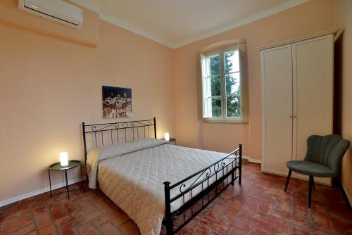 a bedroom with a bed and a chair and a window at L'antico molino in Foligno