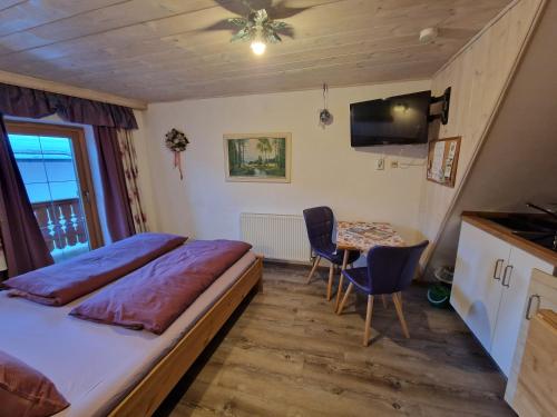 a bedroom with a bed and a table with chairs at Badhaus in Achenkirch