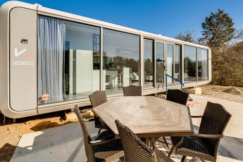 una mesa de comedor y sillas frente a una casa pequeña en 8 Mi to Lake Access Futuristic Capsule Hideaway!, en Valley View