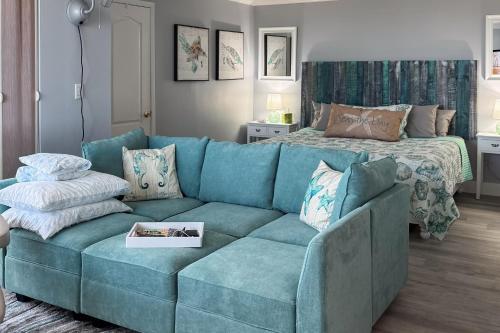 a blue couch in a living room with a bed at Bonita Beach- Seas The Day! in Bonita Springs