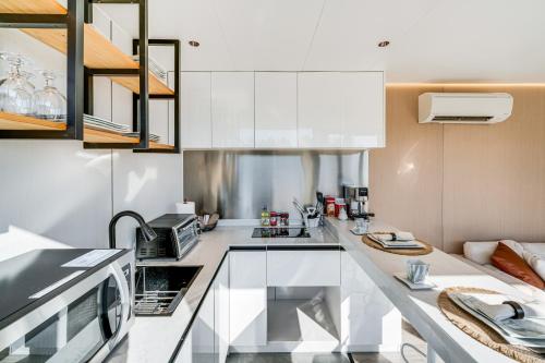 Una cocina con gabinetes blancos y encimera. en 8 Mi to Lake Access Futuristic Capsule Hideaway!, en Valley View