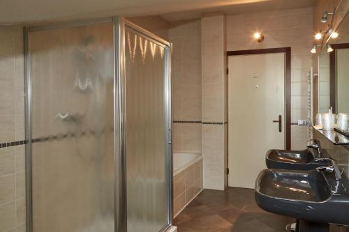 a bathroom with a shower and a sink and a tub at Green Garden APARTMENTS in Chirignago