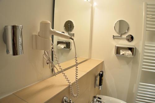 a bathroom with a phone and a mirror at Hotel Jeta in Hamburg