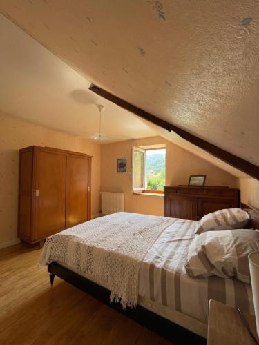 une chambre avec un grand lit et une fenêtre dans l'établissement Le temps des gabariers, à Monceaux-sur-Dordogne