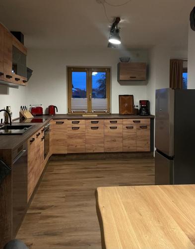 a kitchen with wooden cabinets and a stainless steel refrigerator at Ferientraum am Maibaum in Traunstein