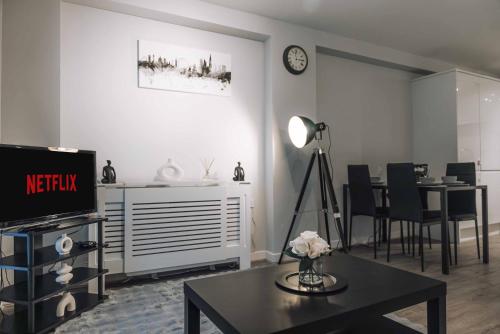 a living room with a table and a tv and a dining room at Luxury 2 Bedroom Apartment near Stratford Station for Corporate and Group Stays in London
