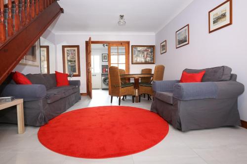 a living room with two couches and a red rug at The Redburn in Belfast