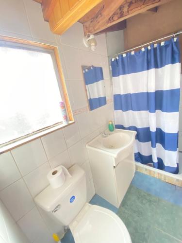 a bathroom with a white toilet and a sink at Habitaciones S&E in Coihaique