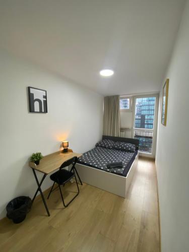 a bedroom with a bed and a desk and a window at Rooms in Warsaw - G39 in Warsaw
