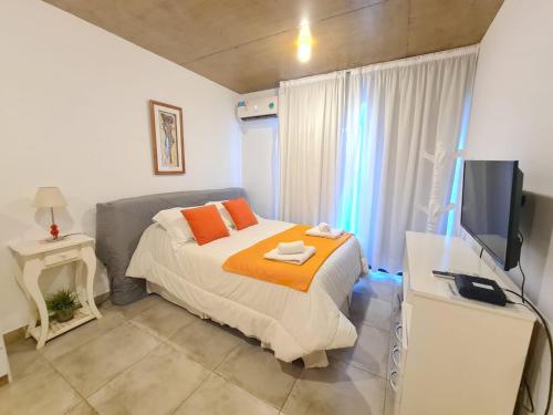 a bedroom with a bed and a flat screen tv at La Morada Rentals & Studio 44 in Belén de Escobar