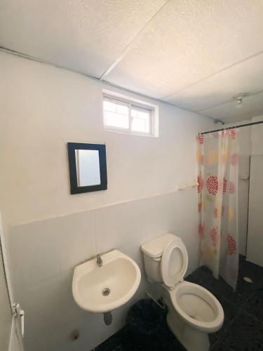 a bathroom with a toilet and a sink at Hotel Puerto Vigia Inn in Cartagena de Indias