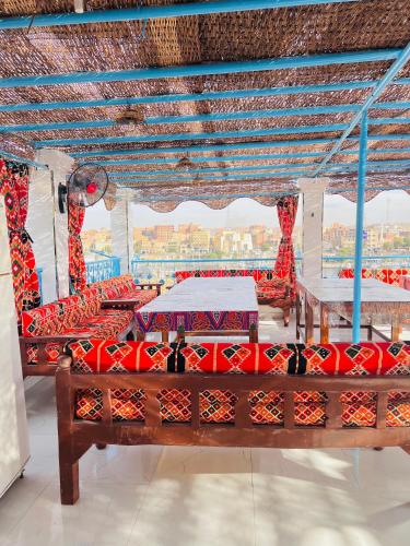 a pavilion with red chairs and a table at JJ Guesthouse in Aswan