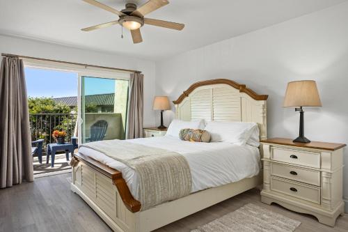 a bedroom with a bed and a window with a patio at Live in the Sunshine-DMBC148N in Solana Beach