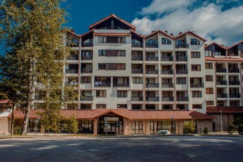 an apartment building in front of a street at Borovets Gardens Aparthotel Seasons Borovets PM in Borovets
