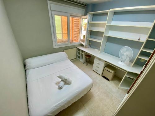 a small room with a bed with a desk and a window at Habitación con baño compartido NO FUMADORES y gente no ruidosa in Getafe