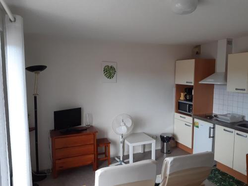 une petite cuisine avec une table et des chaises dans une pièce dans l'établissement Les Alisiers 26, à Eugénie-les-Bains