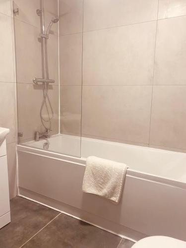 a bathroom with a bath tub with a glass shower at Iconic Location 3 Bed 2 Bath Flat near Regents Park in London