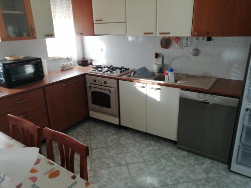 a small kitchen with a stove and a microwave at Casa Ligorio in San Michele Salentino