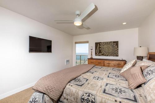 a bedroom with a bed and a flat screen tv at Serenity By The Sea - SBTC202 in Solana Beach