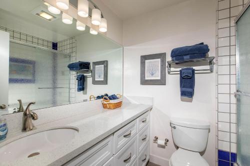 a bathroom with a sink and a toilet and a mirror at Serenity By The Sea - SBTC202 in Solana Beach