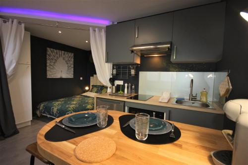 a room with a table and a kitchen and a bed at Résidence Chez Gally in Les Ponts-de-Cé