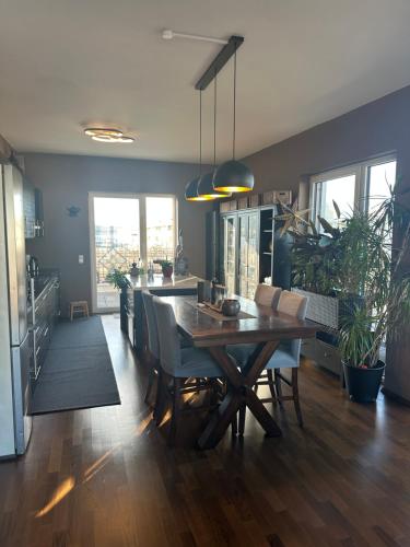 a kitchen and dining room with a wooden table and chairs at Zimmer mit eigenem Badezimmer - 1 Bahn-Station zur Messe und HBF in Frankfurt/Main