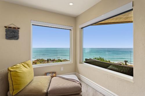 a living room with two large windows and a couch at Relax & Renew - SONG8 in Solana Beach
