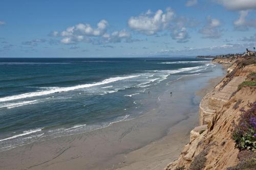 a beach with people walking on it next to the ocean at Relax & Renew - SONG8 in Solana Beach