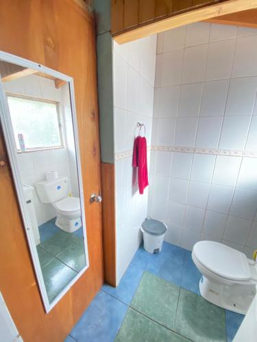 a bathroom with a toilet and a sink at Habitaciones S&E in Coihaique
