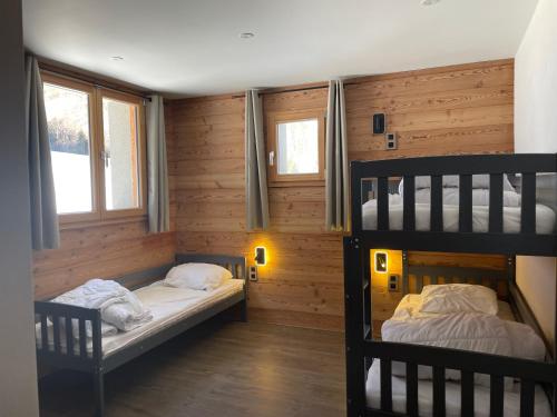 due letti a castello in una stanza con pareti in legno di Chalet Cristal II a Les Contamines-Montjoie