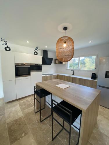 une cuisine avec une table en bois et quelques chaises dans l'établissement Villa neuve - piscine chauffée, à Lorgues