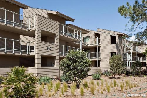 an apartment building with trees in front of it at Don't Worry Beach Happy SONG13 in Solana Beach
