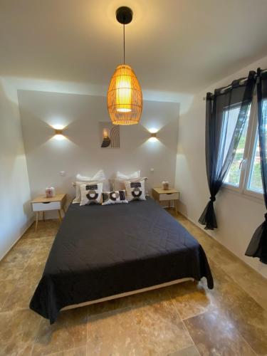 - une chambre avec un lit noir et une lampe pendant dans l'établissement Villa neuve - piscine chauffée, à Lorgues