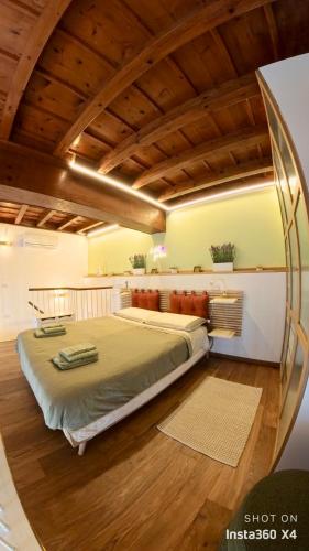 a bedroom with a large bed with a wooden ceiling at Como Lake - Villa Maderni lake view in Como