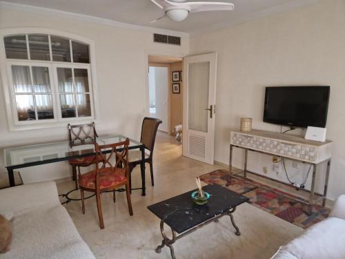 a living room with a table and a tv at Salusahome parking gratuito in Córdoba