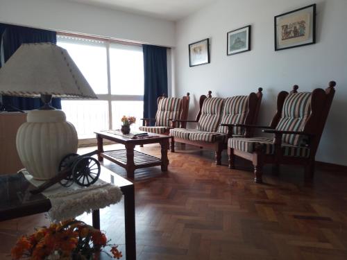a living room with chairs and a table with a lamp at Céntrico y confortable in Concepción del Uruguay