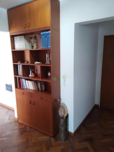 a room with a large wooden book shelf at Céntrico y confortable in Concepción del Uruguay