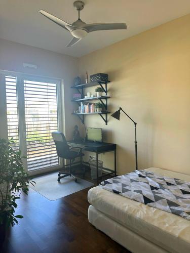 a bedroom with a desk and a bed with a fan at Zimmer mit eigenem Badezimmer - 1 Bahn-Station zur Messe und HBF in Frankfurt/Main