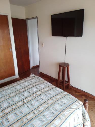 a bedroom with a bed and a flat screen tv at Céntrico y confortable in Concepción del Uruguay