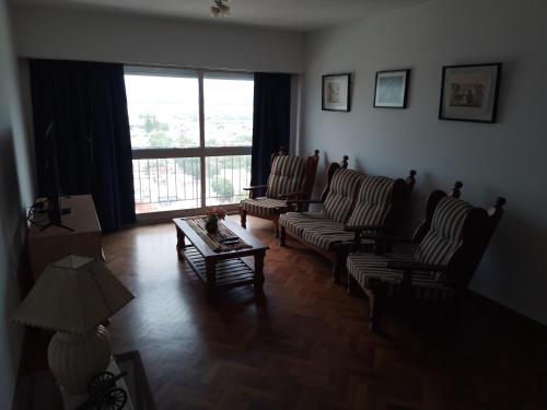 a living room with chairs and a table and a window at Céntrico y confortable in Concepción del Uruguay