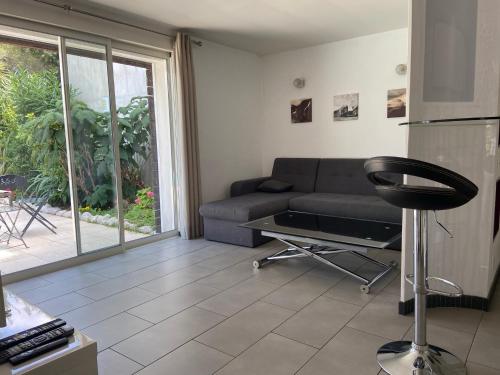 a living room with a couch and a table at Proche bord de mer, au calme, nature avec piscine in La Gaude