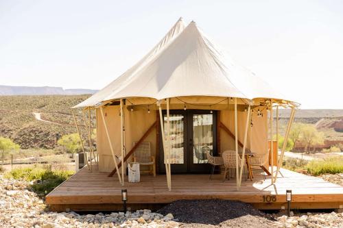 a tent on a wooden deck in the desert at Zion Wildflower Resort in Virgin