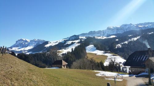 a snow covered mountain with a building on a hill at Appartement bei Selbstversorger auf Kleinbauernhof in Eriz