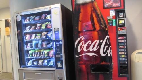 a cocacola coke machine next to a soda machine at Motel 6-West Des Moines, IA in West Des Moines