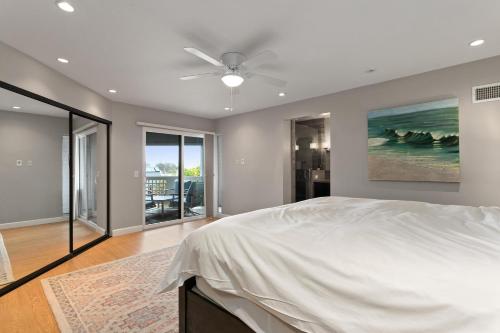 Un dormitorio con una cama y un ventilador de techo. en Vista Pacific - DM1050, en Del Mar