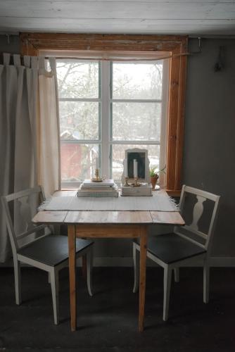 a wooden table with two chairs and a computer on it at Vita Krala in Haddebo