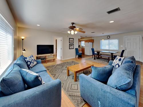 a living room with two blue couches and a table at Pelicans Perch in Pensacola Beach