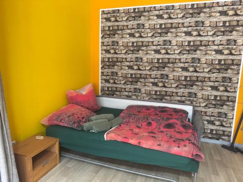 a bedroom with a bed and a brick wall at Schwarzer Kater in Hochstetten-Dhaun