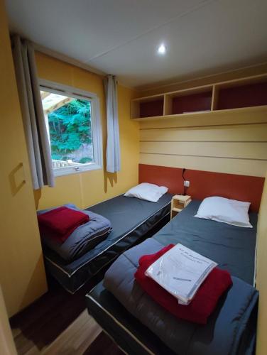 deux lits dans une petite pièce avec une fenêtre dans l'établissement Tiny Sweet Home, à Saint-Chéron