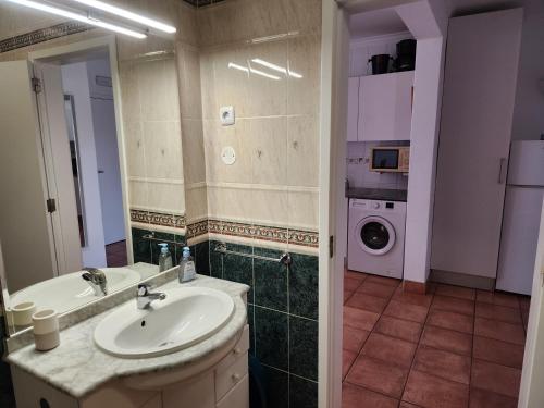 a bathroom with a sink and a washing machine at Vila Apostol in Lagos